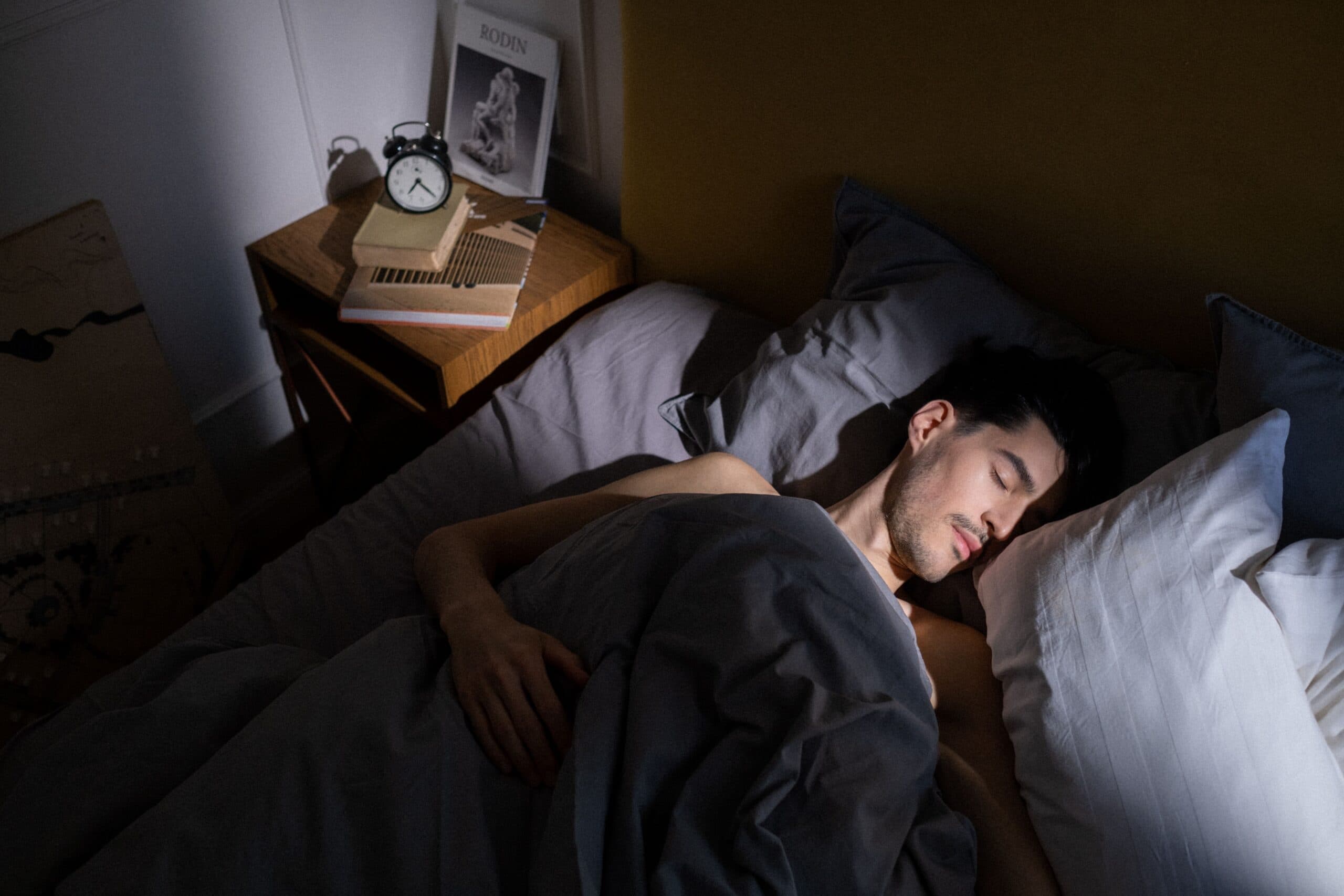 Why Sleep Matters for Long-Term Health, Man Sleeping longer in bed with sunlight